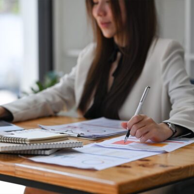 A Woman Sitting At A Table Using A Laptop