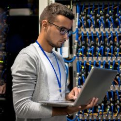 A Man Standing In Front Of A Computer